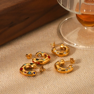 Macro detail of 18K gold stainless steel C-shape earrings set with colorful zircons