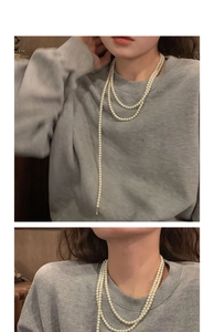Multi-layer white pearl necklace styling on a grey hoodie for a chic vintage look