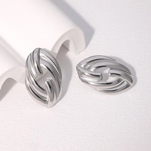 Macro detail of polished silver stainless steel earrings with minimalist twist design