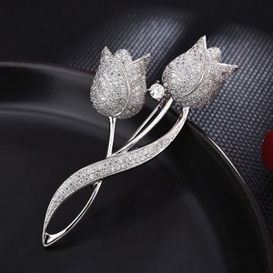 Elegant silver tulip brooch with sparkling rhinestones on a reflective black base