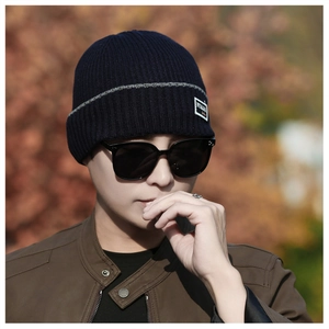 Detailed knit texture of dark blue winter beanie featuring a stylish gray stripe design