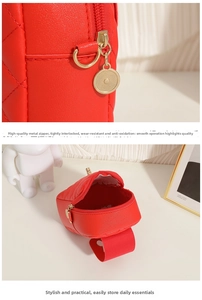 Detail of red quilted mini bag showing gold metal zipper and faux leather texture