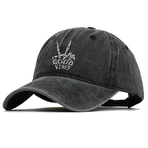 Detail of Good Vibes skeleton hand embroidery on dark grey washed cotton baseball cap