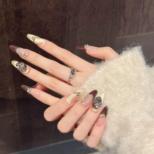 Detailed macro view of caramel latte press-on nails with cat-eye effect and zircon stones