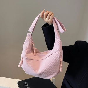 Detail of pink corduroy crescent bag showing soft ribbed texture and woven zipper puller