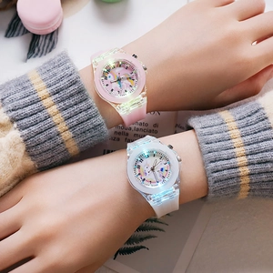 Close-up of pink and white unicorn kids watches with colorful LED glowing lights