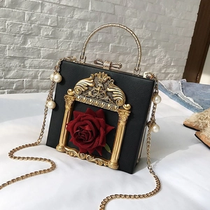 Detail of vintage box bag with 3D red roses, pearl chain, and golden circular handle