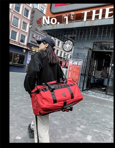 Detail of red oxford fabric fitness bag with black geometric logo and reinforced straps