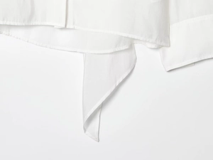 Detail view of the hem and drawstring design on a white minimalist fashion blouse