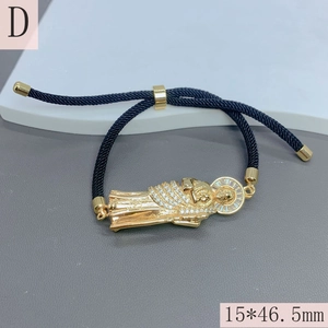 Macro view of gold religious pendant with zircons on adjustable black woven rope strap