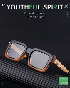 Detail of square frame glasses with golden engraved temples and gradient black amber finish