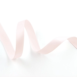 Close-up of a 1.5cm wide light pink double-sided satin ribbon with a glossy texture