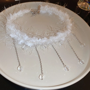 Detail of white plush choker with crystal tassel fringe and silver metal chain