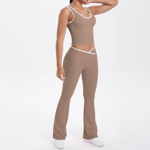 Détail du legging yoga à taille croisée en V et liseré blanc sur débardeur brun