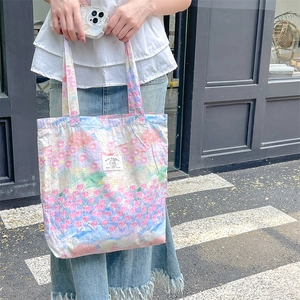 Floral canvas tote bag with pleated fabric and My Rabbit logo carried by a model