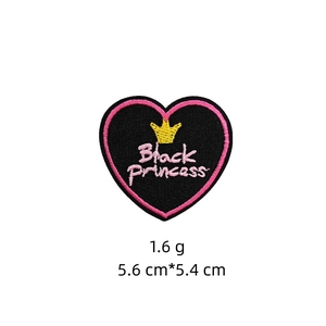 Detailed embroidery of heart-shaped Black Princess patch with pink edges and gold crown