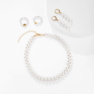 Elegant gold pearl jewelry set including necklace, earrings and heart ring on white stand