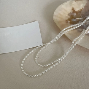 Close-up of double-layer cream pearl necklace with elegant small rice pearls and layering