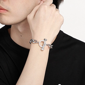 Detail of silver stainless steel chain bracelet with industrial T-bar toggle clasp on wrist
