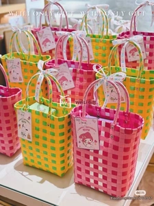 Detailed grid view of colorful hand-woven plastic bucket bags with festive silk ribbons