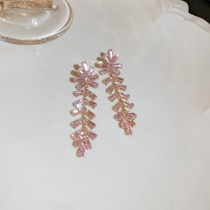 Detailed view of long pink zircon tassel earrings with elegant wheat leaf design on white tray