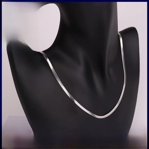 Detailed view of silver flat snake chain necklace with dense metallic scale texture