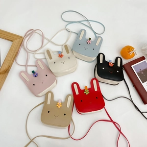 Detailed flat lay of cute cartoon rabbit crossbody bags in various vibrant colors
