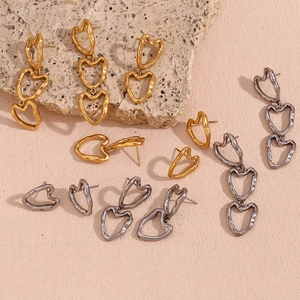 Detail of heart-shaped earrings with hammered texture in gold and silver finishes
