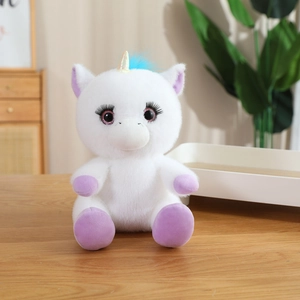 White unicorn plush toy with gold horn and purple accents on a warm interior background