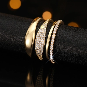 Macro view of gold stacking ring set with pave cubic zirconia and polished metal bands