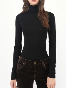 Close-up of black turtleneck knit top showing ribbed texture and slimming hourglass fit