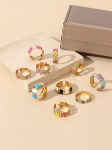 Detail view of colorful enamel flower and striped rings with 18k gold plating