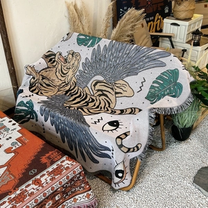 Bohemian woven cotton blanket featuring flying tiger and monstera leaf in a camping setting