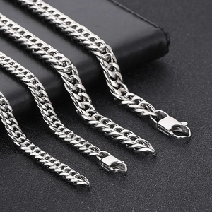 Detailed macro view of three silver stainless steel curb chains with lobster clasps