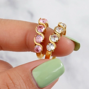 Minimalist gold wave rings with micro-set pink and white cubic zirconia crystals