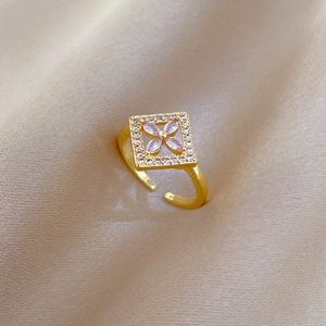 Luxury gold adjustable square floral ring with pink gems and zircons on silk background