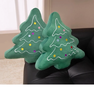 Detailed close-up of soft green plush Christmas tree pillows with colorful dot embroidery