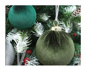 Close-up of velvet Christmas ornaments in moss green and silver on a festive tree branch
