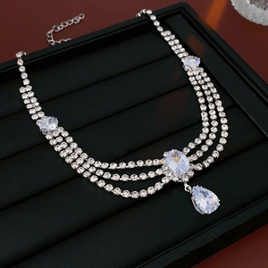 Macro shot of silver triple-layered necklace with clear teardrop zircon pendant