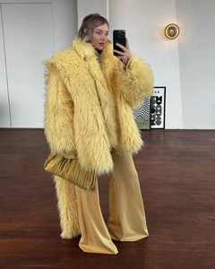 Detailed texture of bright yellow faux mink fur coat paired with matching wide-leg trousers