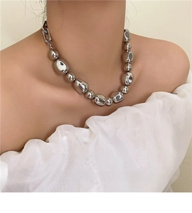 Detail of irregular silver beads and rectangle link on minimalist metal necklace