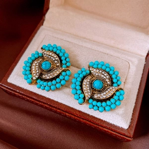 Close-up of bohemian flower earrings with turquoise beads and sparkling rhinestones