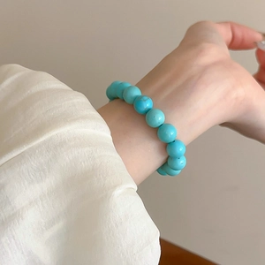 Detail of beaded turquoise bracelet showing natural textures on a model's wrist