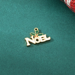 Macro shot of Noel Christmas pendant in gold with white enamel and holly leaf details