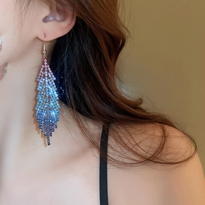 Detail of luxury feather tassel earrings with sparkling gradient rhinestones for women