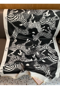 Detailed view of bohemian black and white zebra pattern knit shawl with soft fringe trim
