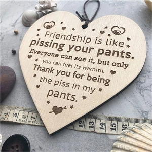 Wooden heart friendship ornament with funny quote on a rustic stone background