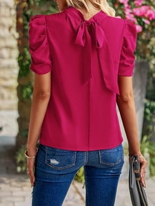 Detail of a women's rose red blouse featuring a stylish back bow tie and puff sleeves design