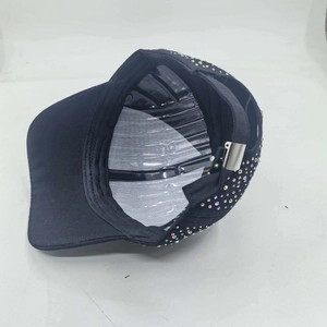 Detailed view of black baseball cap with colorful rhinestone pattern and metal buckle