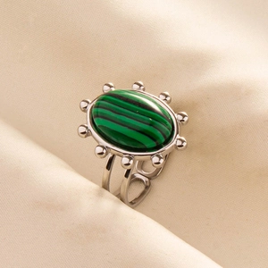 Macro detail of oval malachite ring with sunburst silver setting and hollow band